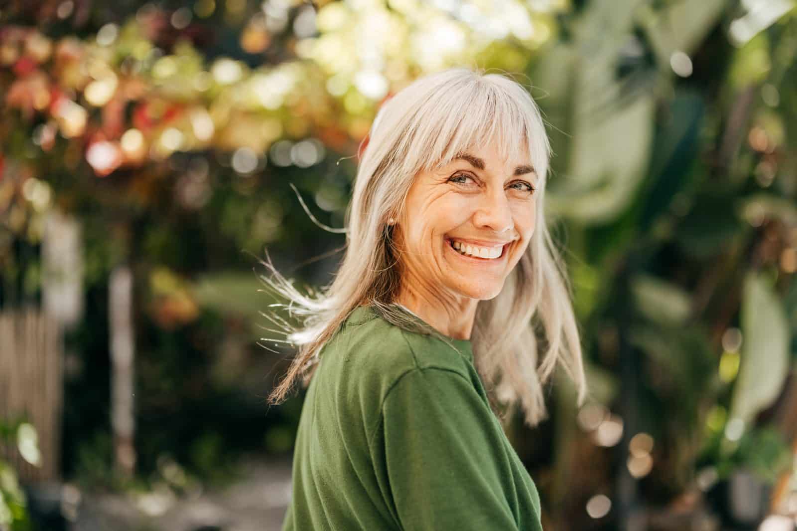 Smiling woman outdoors, illustrating a full-mouth reconstruction patient