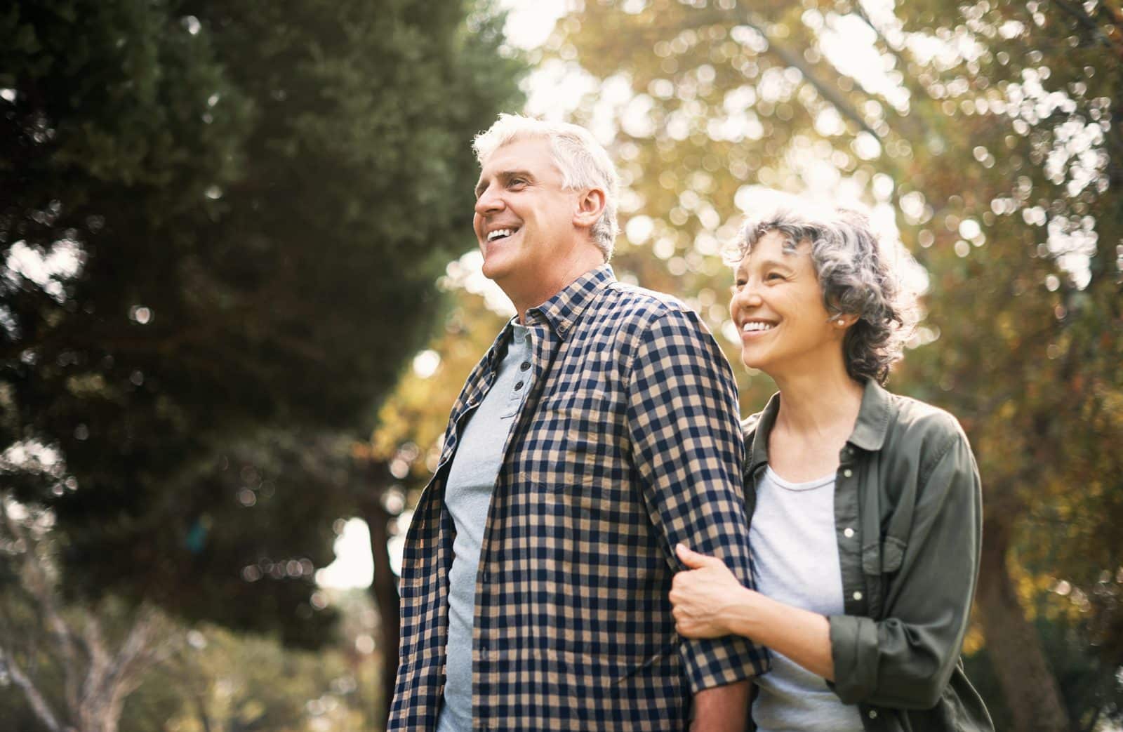 Smiling older couple outdoors, illustrating life after a single-tooth dental implant
