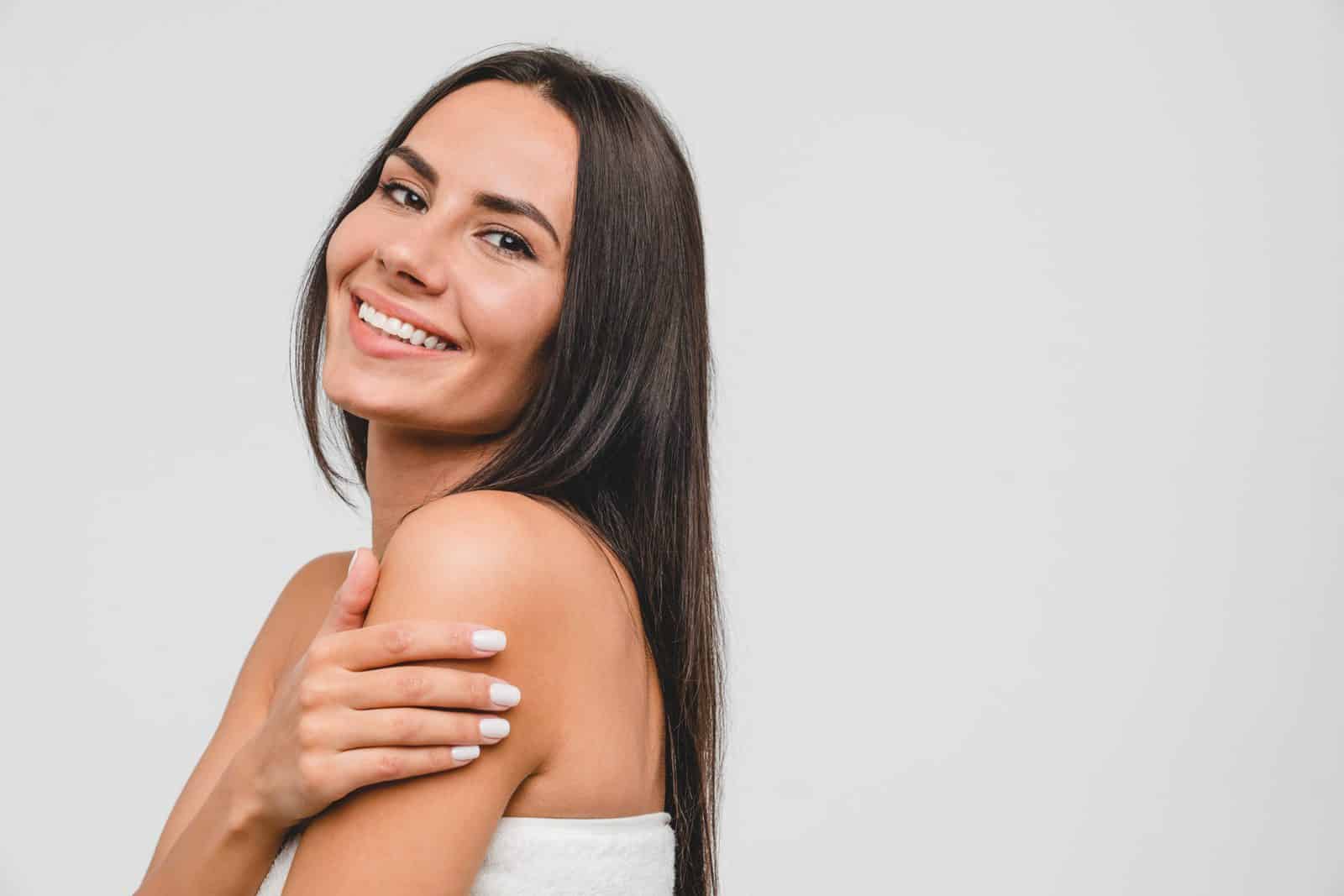 Woman with a bright, natural-looking smile, illustrating porcelain veneers